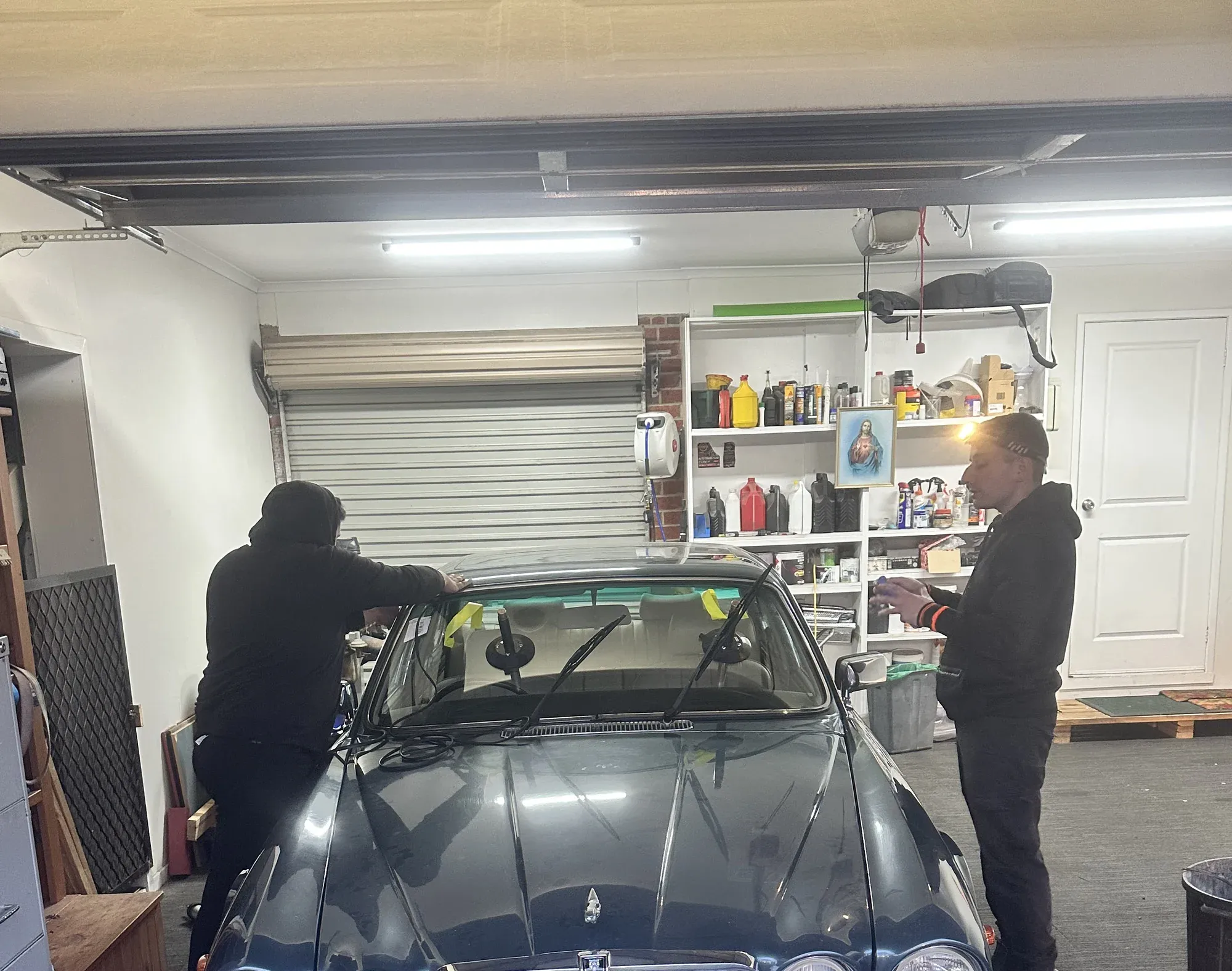 Two auto glass technicians fitting replacement glass to a vehicle