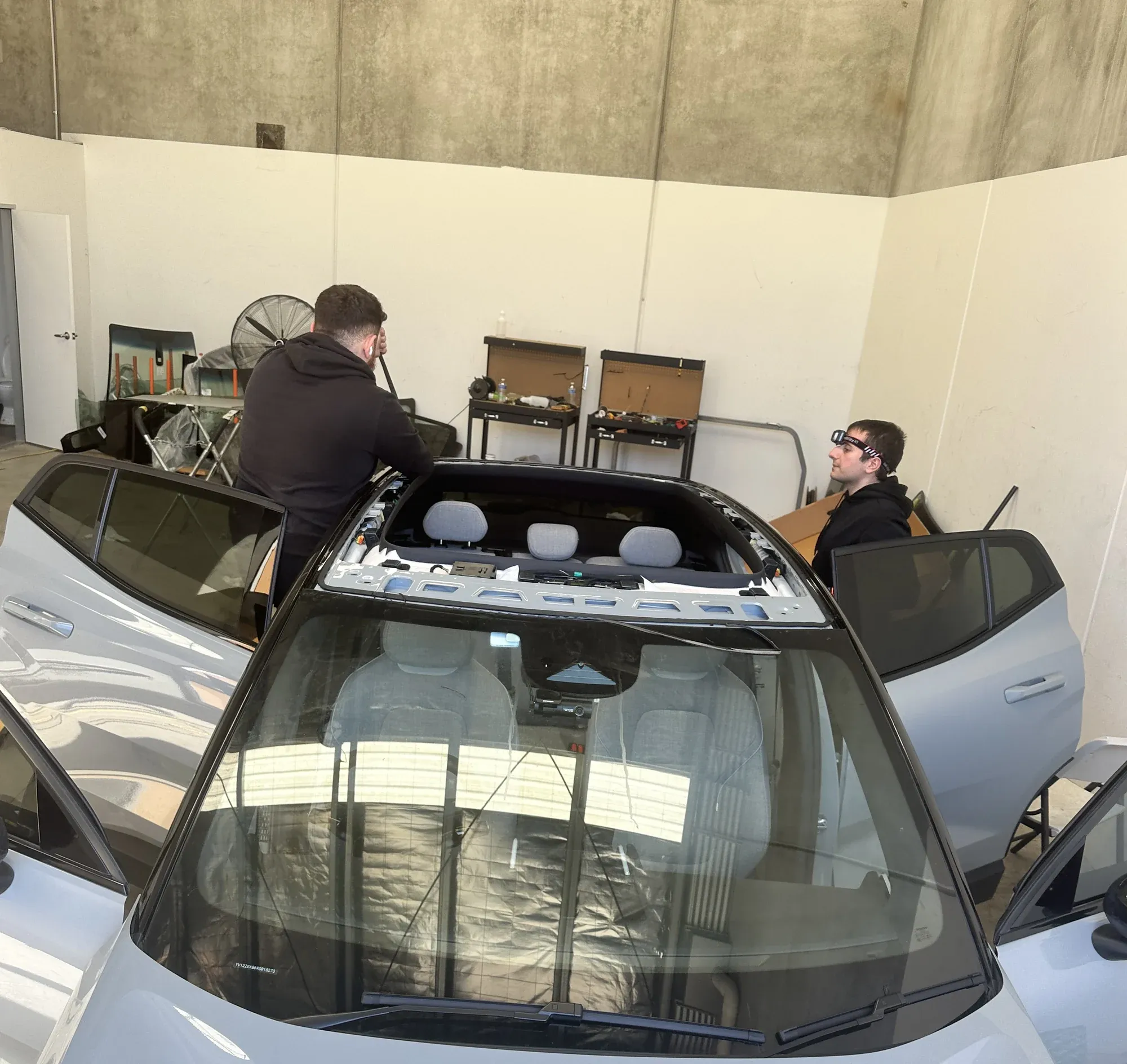 Auto glass technicians working on a vehicle in the workshop